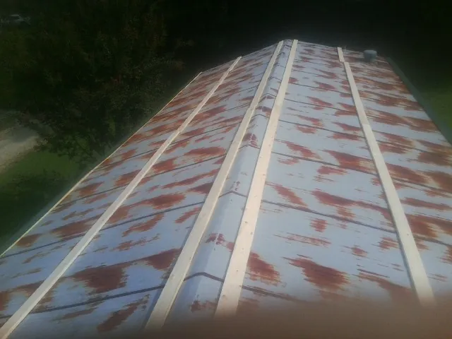 Rusted metal roof panels with new wood purlins before replacement — Storm Damage Roof Repair in Uniontown by Roofing Brothers