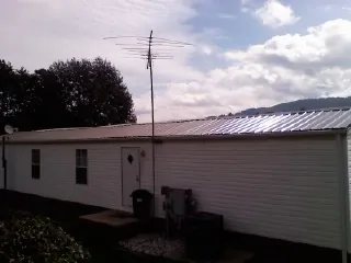 New metal roof on a single wide mobile home with a TV antenna in Uniontown